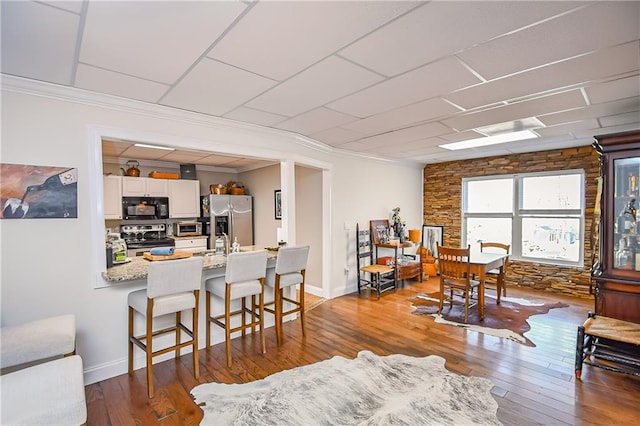 living area with crown molding, baseboards, and dark wood finished floors