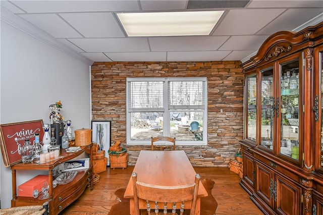 dining space featuring wood finished floors and ornamental molding