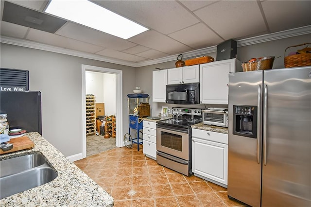 kitchen featuring light stone countertops, stainless steel appliances, white cabinets, and a toaster