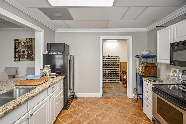 kitchen featuring stainless steel range with electric cooktop, light stone counters, ornamental molding, white cabinets, and black microwave