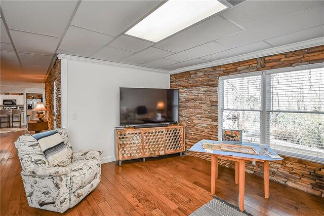 living room with crown molding and wood finished floors