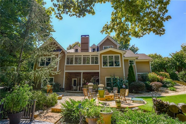 rear view of house with a patio area and a chimney