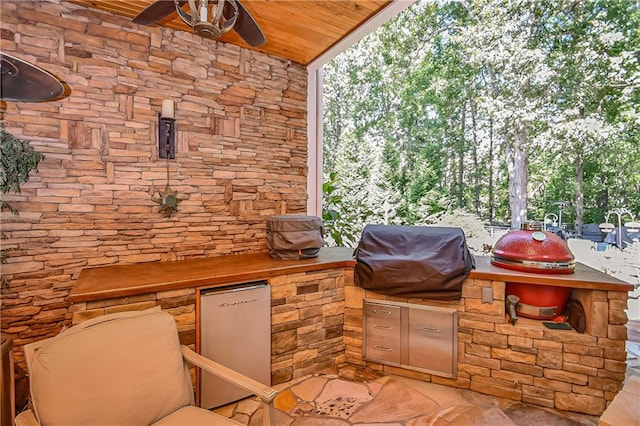 view of patio with exterior kitchen, area for grilling, and a ceiling fan