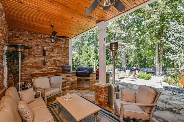 view of patio with an outdoor kitchen, outdoor lounge area, a ceiling fan, and a grill