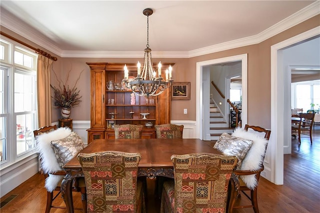 dining space with a chandelier, wainscoting, crown molding, dark wood-style floors, and visible vents