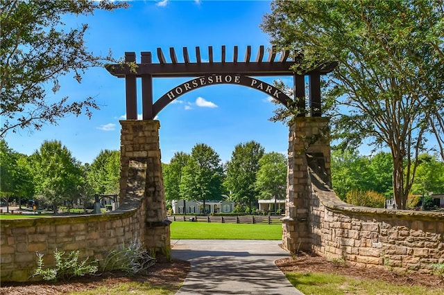 view of property's community with fence and a lawn