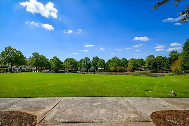 view of property's community featuring a yard and fence