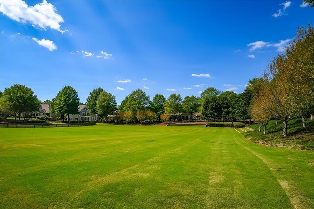 surrounding community with fence and a lawn