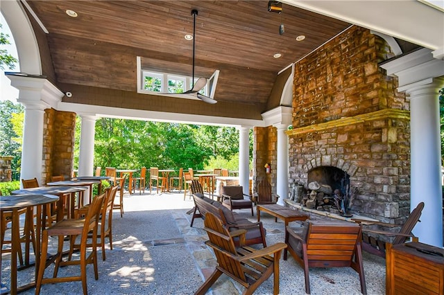 view of patio featuring a bar, a gazebo, and an outdoor stone fireplace