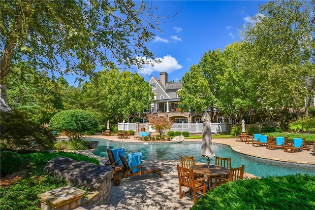 pool with a patio and fence