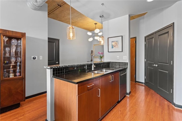 943 Peachtree St NE Unit 1910, Atlanta, GA 30309 - kitchen featuring light wood finished floors, a sink, a peninsula, pendant lighting, and stainless steel dishwasher