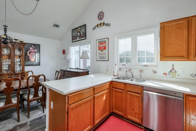 kitchen with a peninsula, a sink, vaulted ceiling, light countertops, and dishwasher