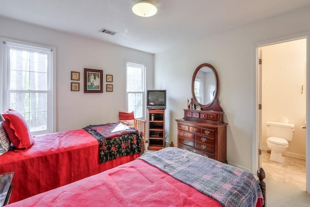 bedroom with visible vents, baseboards, carpet flooring, and ensuite bathroom