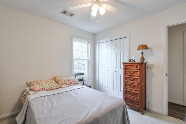 bedroom with light colored carpet, visible vents, a closet, and baseboards