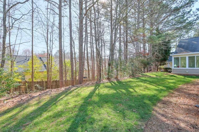 view of yard with fence and a sunroom