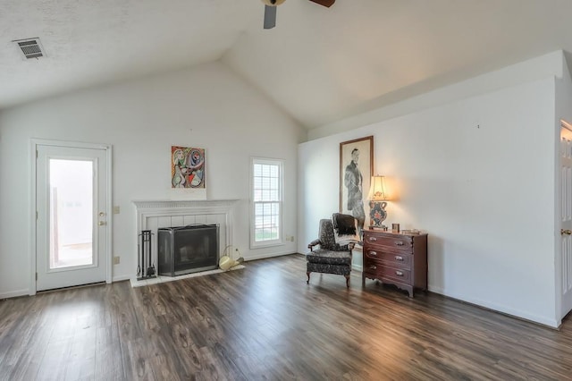 sitting room with visible vents, dark wood-type flooring, a fireplace, lofted ceiling, and ceiling fan