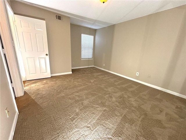 unfurnished bedroom featuring visible vents, baseboards, and dark colored carpet