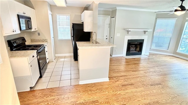 kitchen with black appliances, a ceiling fan, plenty of natural light, open floor plan, and white cabinets