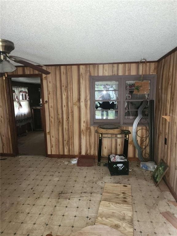 45 Oakwood Dr, Oglethorpe, GA 31068 - unfurnished living room with tile patterned floors, wooden walls, ceiling fan, and a textured ceiling
