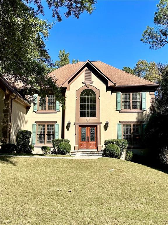 view of front of home with a front lawn and french doors