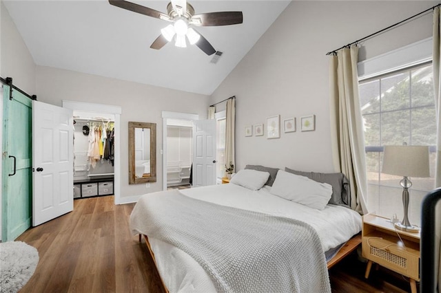 3313 Harmon Ridge Ct, Buford, GA 30519 - bedroom with a barn door, a spacious closet, wood finished floors, connected bathroom, and a ceiling fan