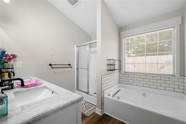 3313 Harmon Ridge Ct, Buford, GA 30519 - bathroom with wood finished floors, lofted ceiling, a garden tub, a stall shower, and double vanity