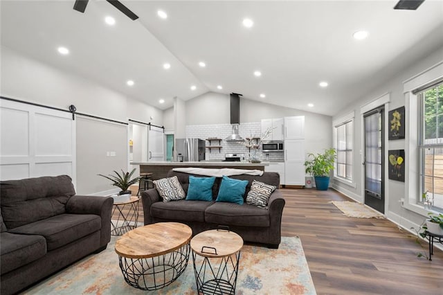 3313 Harmon Ridge Ct, Buford, GA 30519 - living area featuring vaulted ceiling, wood finished floors, a barn door, recessed lighting, and a ceiling fan