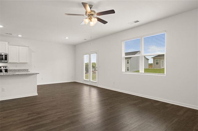 unfurnished living room with ceiling fan and dark wood-type flooring