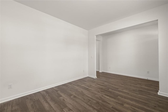 empty room with dark hardwood / wood-style flooring