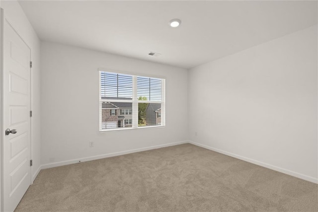 spare room featuring light colored carpet