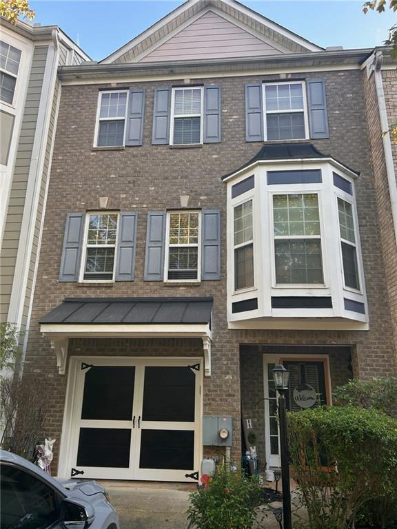 multi unit property featuring brick siding and a garage