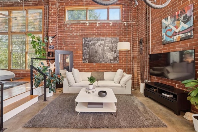 living room featuring concrete floors and brick wall