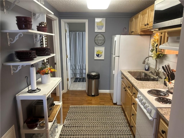 kitchen featuring dark wood-style flooring, light stone counters, a sink, ventilation hood, and electric range