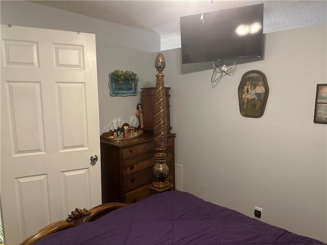 bedroom featuring a textured ceiling and visible vents