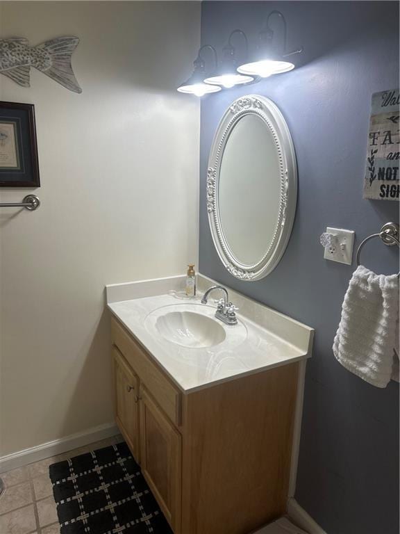 bathroom with baseboards, vanity, and tile patterned flooring
