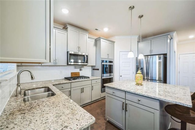 kitchen featuring tasteful backsplash, gray cabinets, stainless steel appliances, and a sink