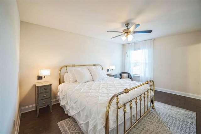 bedroom featuring a ceiling fan, baseboards, and wood finished floors