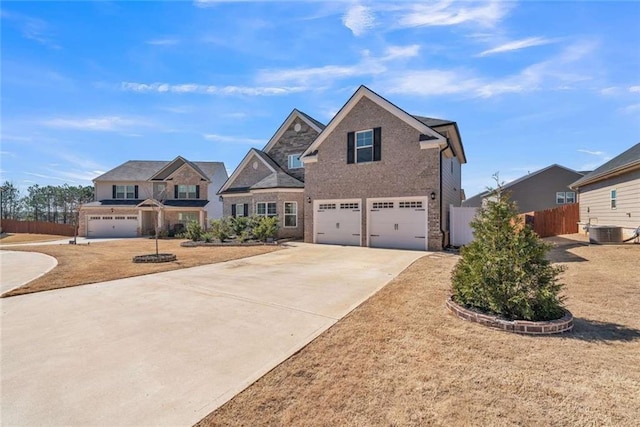 view of front facade featuring brick siding, central air condition unit, an attached garage, fence, and driveway