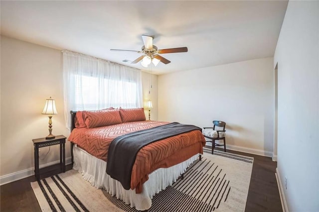 bedroom with wood finished floors, a ceiling fan, and baseboards