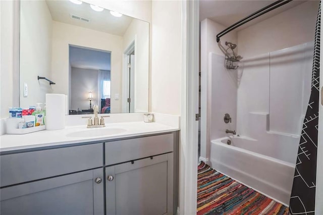 full bathroom featuring washtub / shower combination, visible vents, wood finished floors, and vanity