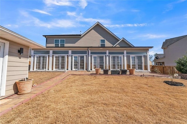 rear view of house with french doors and a yard