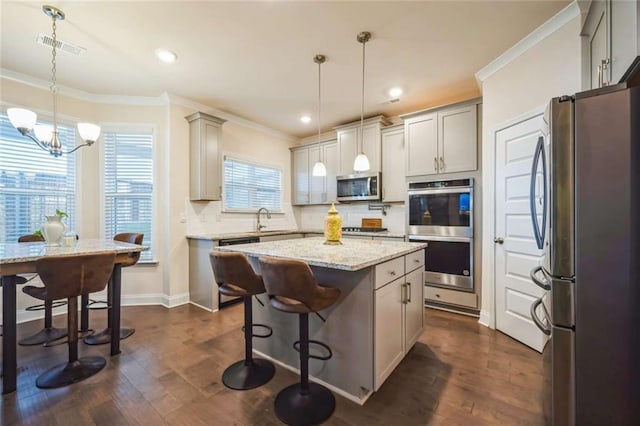 kitchen with dark wood finished floors, ornamental molding, stainless steel appliances, and backsplash