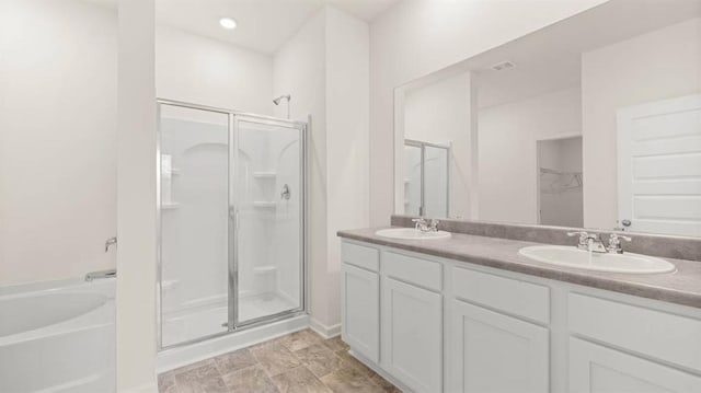 bathroom featuring vanity and independent shower and bath