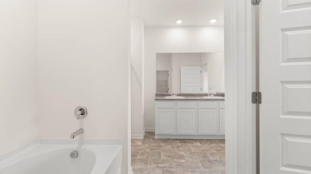 bathroom with a bathing tub and vanity