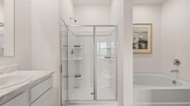 bathroom featuring shower with separate bathtub and vanity