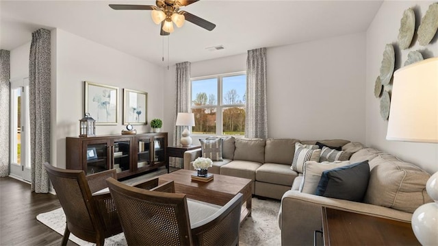 living room featuring dark wood-type flooring and ceiling fan