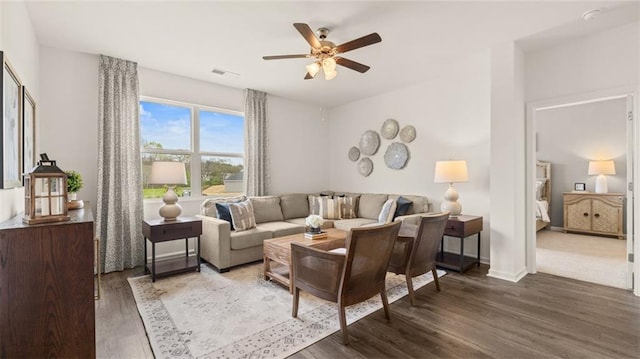 living room featuring ceiling fan and dark hardwood / wood-style flooring