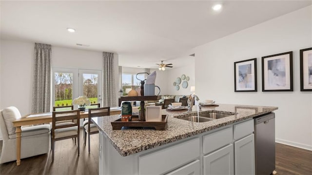 kitchen featuring white cabinetry, sink, dark wood-type flooring, a kitchen island with sink, and stainless steel dishwasher