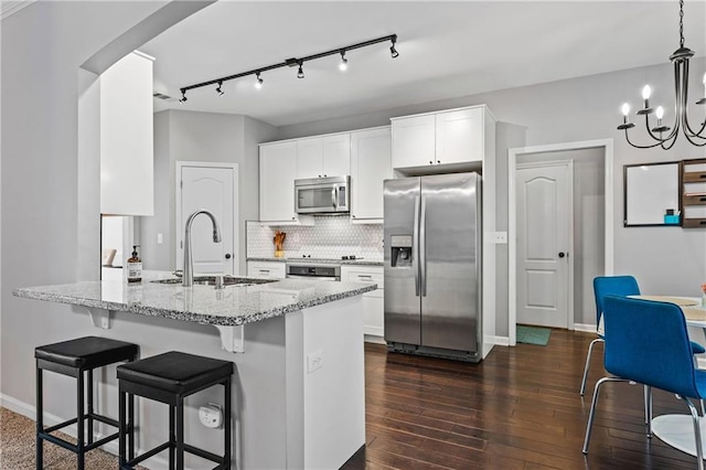 3174 Vickery Dr NE, Marietta, GA 30066 - kitchen with stainless steel appliances, a sink, light stone countertops, dark wood-style floors, and a kitchen bar