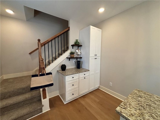 stairs featuring recessed lighting, wood finished floors, and baseboards